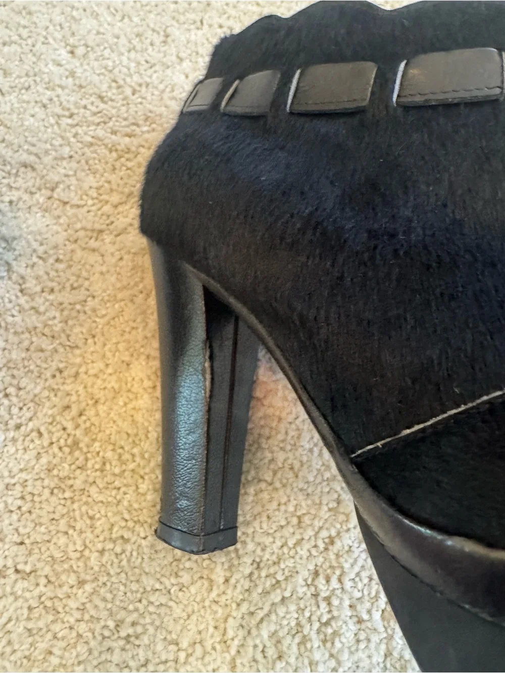 ZORAIDE black calf hair ankle booties with leather strap and tassel accents.